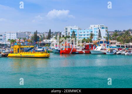 Ayia Napa, Zypern - 12. Juni 2018: Vergnügungsboote, die in Agia Napa festgemacht sind, gehen gewöhnliche Menschen die Küstenstraße entlang. Resort Stadt am äußersten östlichen Ende von Stockfoto