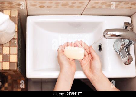 Zwei Kinderpalmen über einem Waschbecken im Badezimmer mit weißem Schaumstoff. Stockfoto