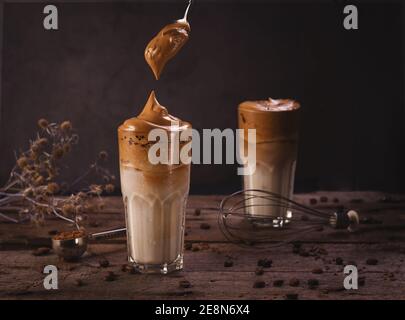 Dalgona Kaffee. Schlagsahngetränk mit Instant-Kaffee beliebt in Korea cremigen Cocktail in hohen Gläsern. Dunkle launische Food-Fotografie Stockfoto