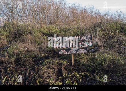 Riverside Schild sayin 'Post Covid Paradise - Niemand links Hinter' Stockfoto