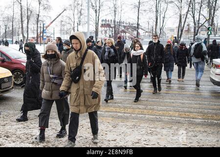 Moskau, Russland - 31. Januar 2021, Menschen mit medizinischen Masken auf ihren Gesichtern überqueren die Straße an einem Fußgängerübergang. Stockfoto