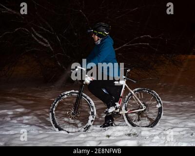 Mountainbike-Fahrer Junge im Winter. Junger Mann Reiten fetten Reifen Fahrrad im Winter. Boy schieben mtb in tiefen klebrigen Schnee. Stockfoto