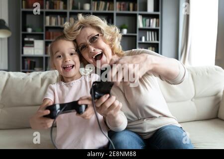 Überglücklich verschiedene weibliche Generationen Familie spielen Videospiele zu Hause. Stockfoto