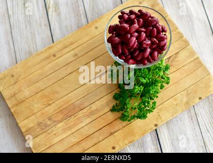 Ganze Lebensmittel rote Kidney Bohnen in einfachen Glas Schüssel für gesunde Ernährung Leben mit frischen grünen Kräutern, Konzept, Kopie Raum angezeigt Stockfoto