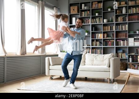 Glücklicher junger Vater in der Luft lachend kleine Kind Tochter heben. Stockfoto