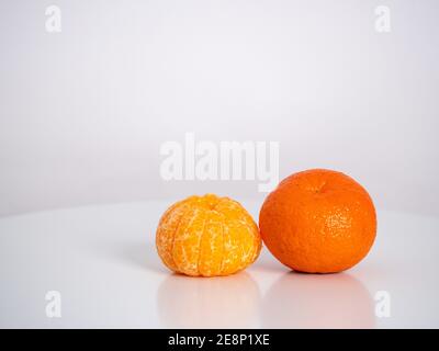 Nahaufnahme orange, geschälte zweite Mandarine auf der Haut Stockfoto