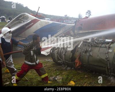 Rettungskräfte haben am 16. September 2007 die Stelle eines Flugzeugabsturzes auf dem Flughafen von Phuket in Thailand begutachte. Ein Billigflugzeug mit 128 Personen an Bord stürzte auf der thailändischen Resortinsel Phuket ab und tötete 88 Menschen, als es sich auflöste und in Flammen aufging, während es versuchte, bei starkem Regen zu landen. Die restlichen 42 Menschen an Bord des Fluges von Bangkok überlebten und wurden in nahe gelegenen Krankenhäusern wegen einer Vielzahl von Verletzungen behandelt. Foto von ABACAPRESS.COM Stockfoto