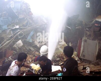 Rettungskräfte haben am 16. September 2007 die Stelle eines Flugzeugabsturzes auf dem Flughafen von Phuket in Thailand begutachte. Ein Billigflugzeug mit 128 Personen an Bord stürzte auf der thailändischen Resortinsel Phuket ab und tötete 88 Menschen, als es sich auflöste und in Flammen aufging, während es versuchte, bei starkem Regen zu landen. Die restlichen 42 Menschen an Bord des Fluges von Bangkok überlebten und wurden in nahe gelegenen Krankenhäusern wegen einer Vielzahl von Verletzungen behandelt. Foto von ABACAPRESS.COM Stockfoto