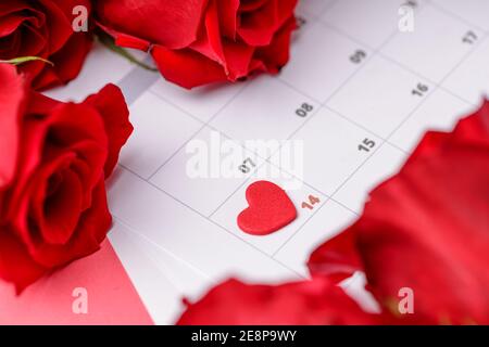 Valentinstag. Rote Feuerstellen und Rosen auf Kalenderseite. 14. Februar des Valentinstag. Rosa Hintergrund. Stockfoto