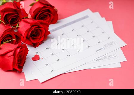 Valentinstag. Rote Feuerstellen und Rosen auf Kalenderseite. 14. Februar des Valentinstag. Rosa Hintergrund. Stockfoto