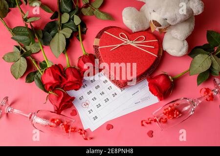 Valentinstag. Rote Feuerstellen und Rosen auf Kalenderseite. 14. Februar des Valentinstag. Rosa Hintergrund. Stockfoto