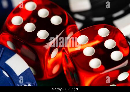 Ein Vollformat-Makro ein Paar rot durchscheinender Würfel im Casino-Stil, die ein Paar Sechsen mit schwarzen und blauen Wettchips zeigen. Stockfoto