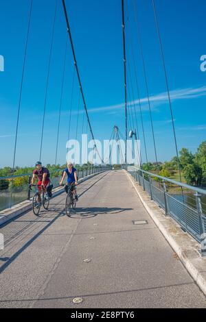 Zwei Radfahrer fahren Fahrrad durch moderne Fußgängerbrücke über die Elbe bei Magdeburg, Deutschland, Anfang Herbst Stockfoto