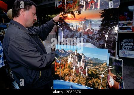 Männlicher Tourist, der Souvenirs und Postkarten anschaut, Schloss Neuschwanstein, König Ludwig Tour, Hohenschwangau, Allgäu, Bayern, Deutschland Stockfoto