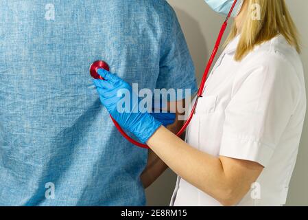 Junge beim Hausarzt. Lungenbereich mit Stethoskop untersucht. Kinderarzt prüft die Gesundheit, hört dem Kind mit einem Stethoskop zu. Stockfoto