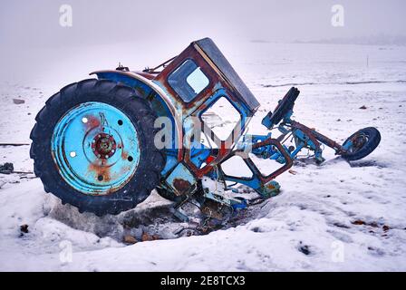 Zerlegte Teile des alten Traktors als Müll und Verschmutzung auf einem Berggletscher; Konzept der Umweltprobleme Stockfoto