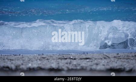 Meer mit blauem Wasser und großen weißen glitzernden Wellen in Ein heißer Sommerurlaub Stockfoto