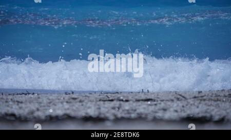 Meer mit blauem Wasser und großen weißen glitzernden Wellen in Ein heißer Sommerurlaub Stockfoto