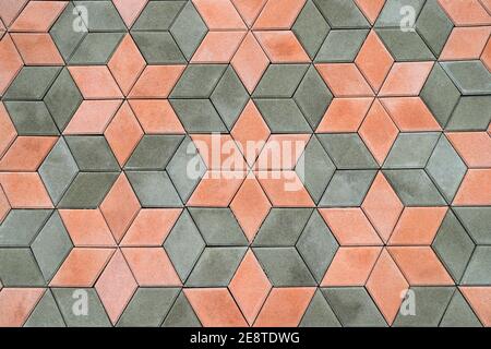 Gehweg, Fußweg, Weg aus schönen modernen Pflasterplatten, geometrische Muster. Abstrakt Grau orange Hintergrund, Textur von Zementsteinplatten. Stockfoto