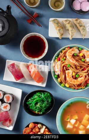 Japanisches Abendessen, flache Aufnahme einer Vielzahl japanischer Gerichte auf blauem Hintergrund Stockfoto