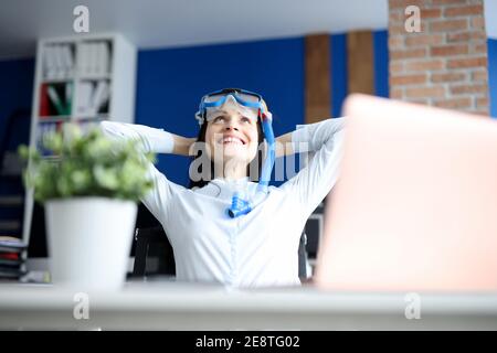 Frau in Tauchmaske träumen von Meer am Arbeitsplatz Stockfoto