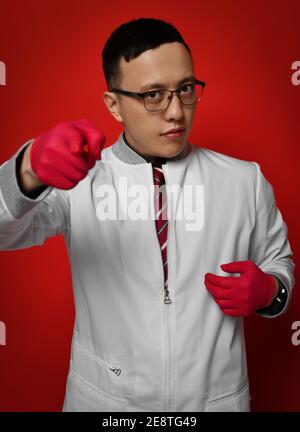 Porträt des jungen Mannes Arzt Urologe oder Proktologe in der Medizin Kittel und Handschuhe zeigen mit dem Finger auf die Kamera Stockfoto