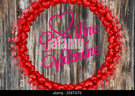 Be my Valentine Inschrift auf dem Holzhintergrund mit dekorativen Herzen. Stockfoto