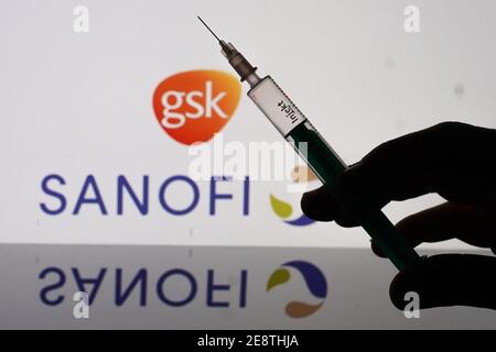 Berlin, Deutschland. Januar 2021. Eine Spritze ist vor den Logos der Firmen Sanofi und GlaxoSmithKline zu sehen. Beide Unternehmen wollen Corona-Impfstoffe in naher Zukunft gemeinsam herstellen. Quelle: Jörg Carstensen/dpa/Alamy Live News Stockfoto