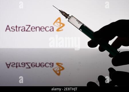 Berlin, Deutschland. Januar 2021. Vor dem Logo der Firma AstraZeneca ist eine Spritze zu sehen. Quelle: Jörg Carstensen/dpa/Alamy Live News Stockfoto