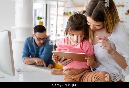 Eltern helfen Kindern, die online zu Hause studieren. Lockdown und Online-Schule, Technologie-Konzept. Stockfoto