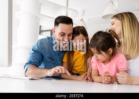 Eltern helfen Kindern, die online zu Hause studieren. Lockdown und Online-Schule, Technologie-Konzept. Stockfoto