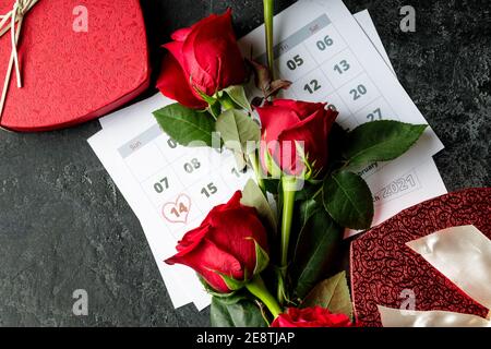 Valentinstag. Rote Feuerstellen und Rosen auf Kalenderseite. 14. Februar des Valentinstag. Rosa Hintergrund. Stockfoto