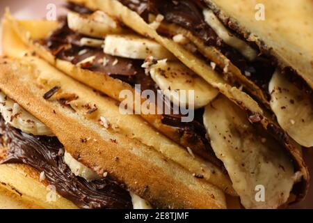Leckere Crepes mit Schokoladenpaste, Banane und Nüsse, close up Stockfoto