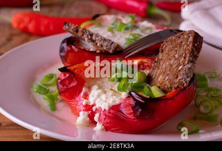 Vegetarische gefüllte Paprika mit Quark und Vollkornbrot serviert Auf einer Platte mit Gabel Stockfoto