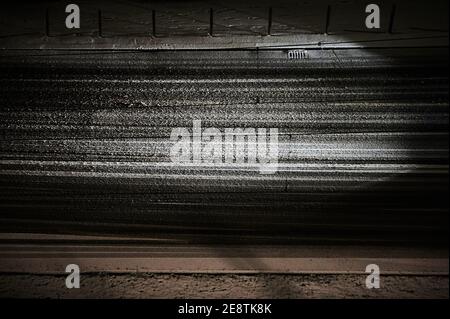 Berlin, Deutschland. Januar 2021. Die Scheinwerfer eines Autos beleuchten den Schnee auf der Straße. Das Auto fährt im Dunkeln auf einer verschneiten Straße in Berlin Mitte. Quelle: Annette Riedl/dpa/Alamy Live News Stockfoto