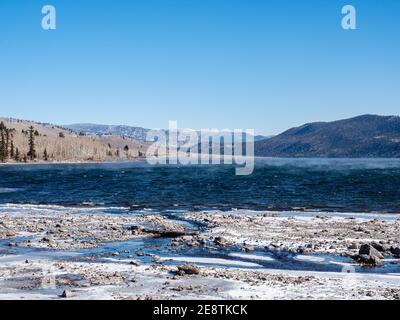 Verdunstungsnebel steigt vor dem Fish Lake im Winter im Fishlake National Forest, Richfield, Utah im Winter, Spätherbst an klaren kalten Tag mit Schnee Stockfoto