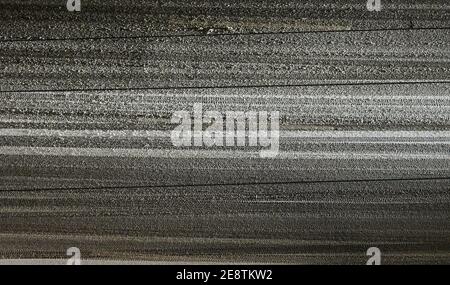 Berlin, Deutschland. Januar 2021. Die Scheinwerfer eines Autos beleuchten den Schnee auf der Straße. Das Auto fährt im Dunkeln auf einer verschneiten Straße in Berlin Mitte. Quelle: Annette Riedl/dpa/Alamy Live News Stockfoto