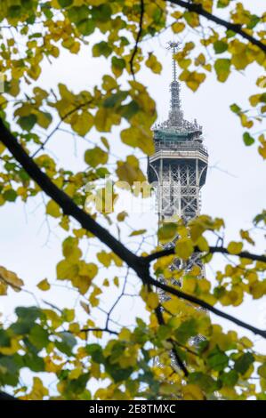 Der Eiffelturm, Paris, Frankreich im Frühherbst durch Bäume gesehen. Stockfoto