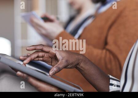 Nahaufnahme von Personen, die auf einer Geschäftskonferenz in Reihe sitzen, Fokus auf afroamerikanische weibliche Hände, die ein digitales Tablet im Vordergrund halten, Kopie Stockfoto