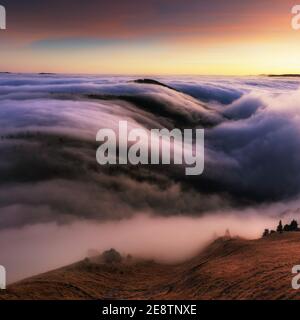 Berglandschaft über Wolken bei Sonnenuntergang in der Slowakei mit Wald Und Sonne Stockfoto