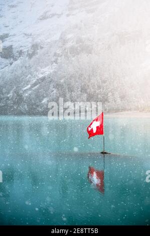 Schweizer Flagge in Oeschinen Bergsee Stockfoto