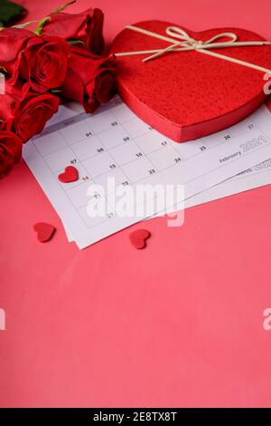 Valentinstag. Rote Feuerstellen und Rosen auf Kalenderseite. 14. Februar des Valentinstag. Rosa Hintergrund. Stockfoto