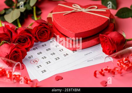 Valentinstag. Rote Feuerstellen und Rosen auf Kalenderseite. 14. Februar des Valentinstag. Rosa Hintergrund. Stockfoto