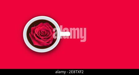 Rote Rose in Tasse Kaffee auf rotem Hintergrund. Happy Valentines Day Konzept. Stockfoto