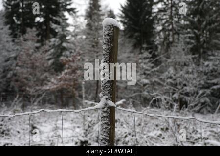Weiße Schneekappen an den Zaunpfosten Stockfoto
