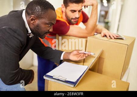 Lagerkaufmann und Unternehmer am Tablet-Computer mit Paketen Beim Online-Versand Stockfoto