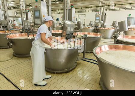 Ein Mann, der Milch in einem mit Kupfer ausgekleideten Bottich rührt parmigiano reggiano von Parmessan Käse in einer Fabrik in Bologna Italien Stockfoto