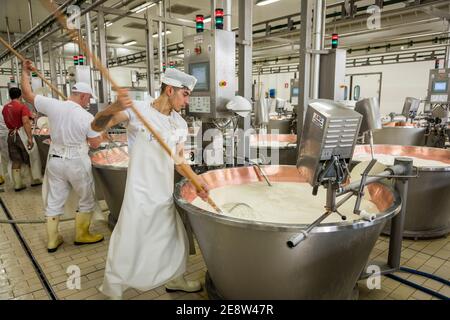 Ein Mann, der Milch in einem mit Kupfer ausgekleideten Bottich rührt parmigiano reggiano von Parmessan Käse in einer Fabrik in Bologna Italien Stockfoto