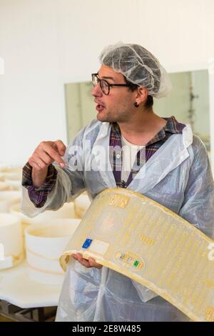 Ein Mann, der eine Plastikform zeigt, die für die Herstellung von Parmessan verwendet wird Oder Parmigioano reggiano Käse in einer Fabrik in Bologna Italien Stockfoto