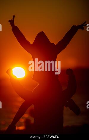 Ein Paar feiert seine Jugend vor dem Sonnenuntergang Stockfoto